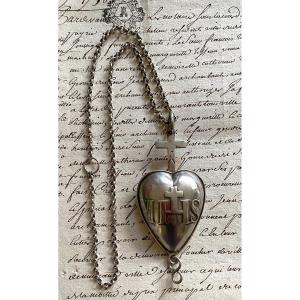 Ex Voto religieux en argent XIXème et sa chaîne. Cœur de Jésus surmonté d’une croix. IHS. 