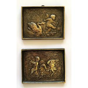 Paire de petits bas-reliefs en bronze XIXème. Angelots poursuivis par un cygne et un échassier.