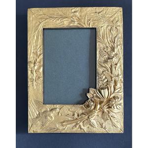 Cadre en bronze doré XIXème. Décor en relief fleurs, papillons et oiseau. 