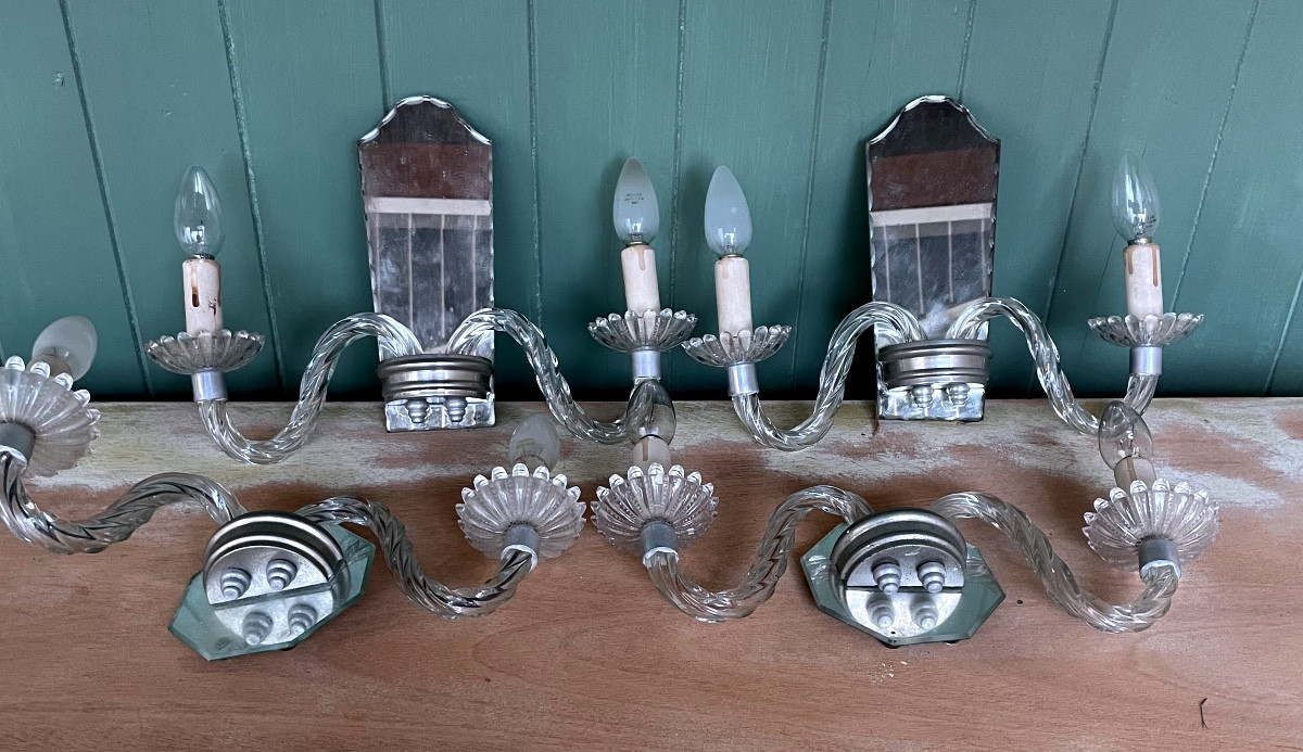 4 Twisted Glass Sconces On A Mirror Background