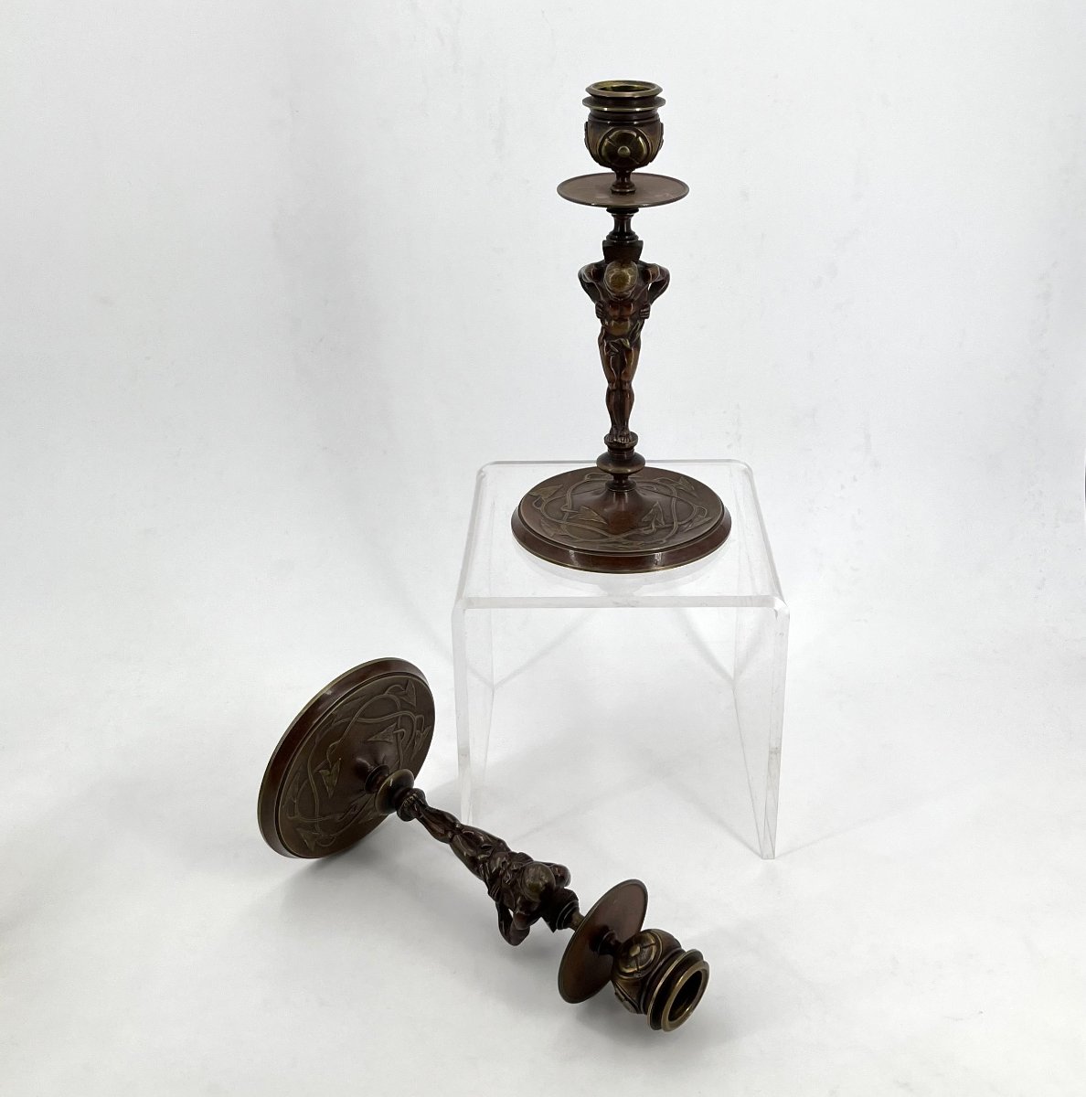 Paire de bougeoirs anciens en bronze patiné figurant des Atlantes, fin XIXe siècle.