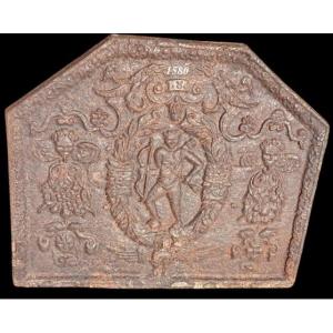 Haute époque. Plaque de cheminée à l'image de Cupidon et de grotesques, datée 1580. TBE