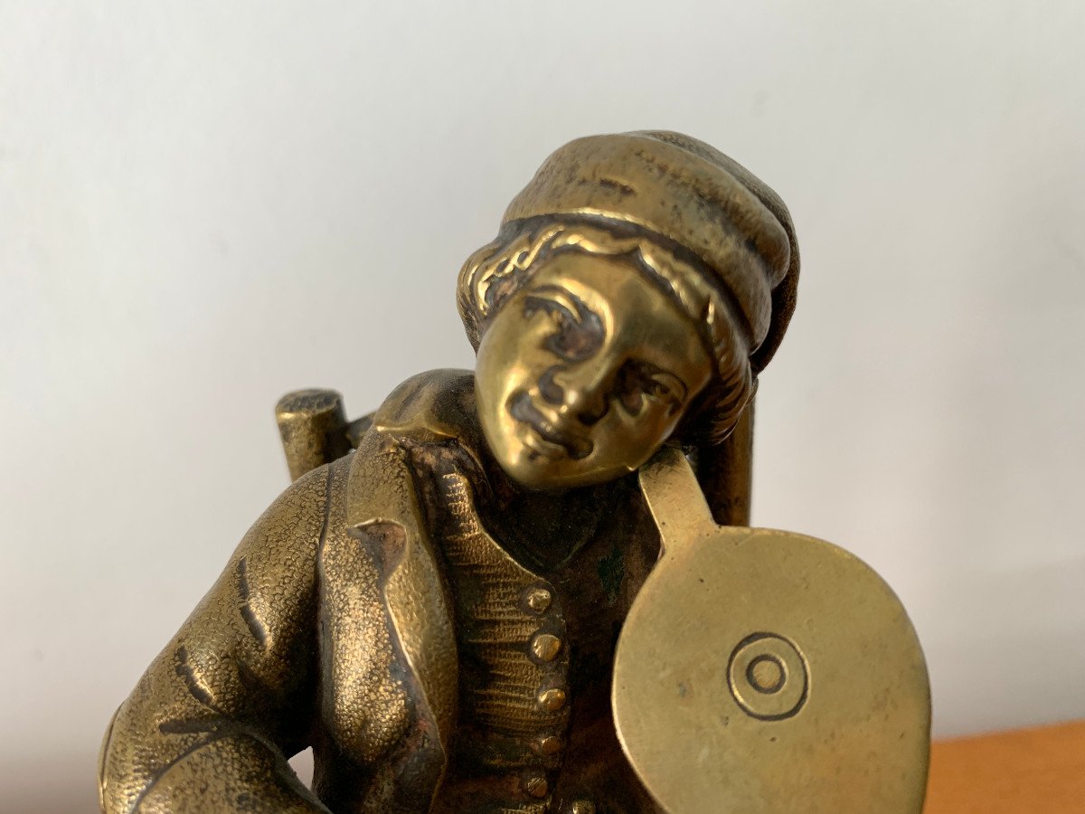 Bronze Newsboy Playing The Violin With A Bellows-photo-1