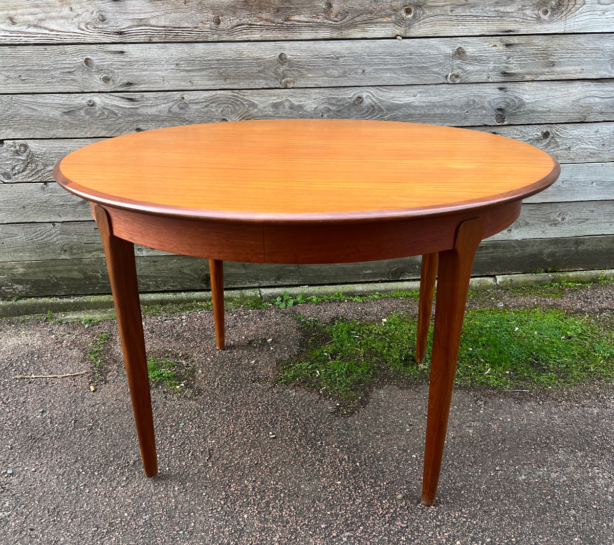 Table ronde à bandeau 4 pieds en teck , modèle à rallonges.