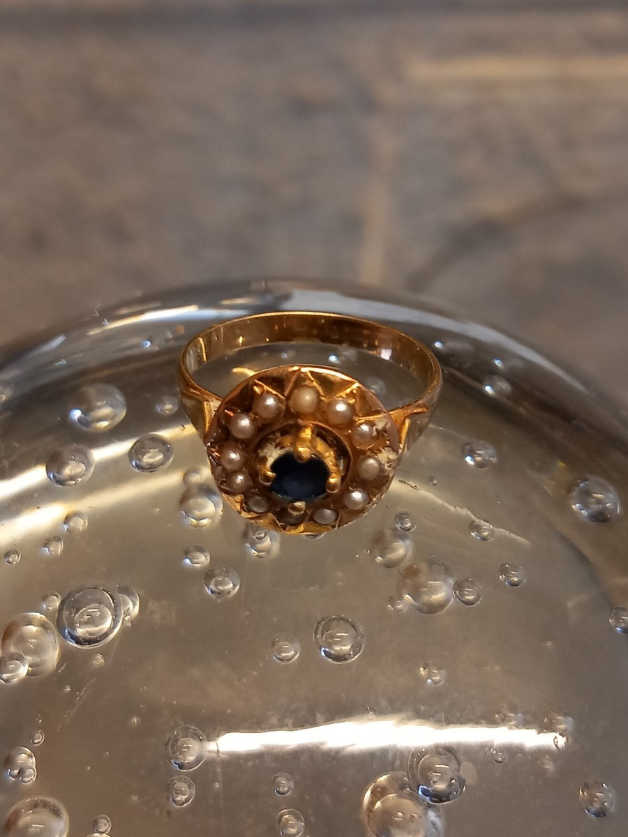 Bague circulaire en or 18k, au centre un saphir entouré d'un rang de demi perles.-photo-1