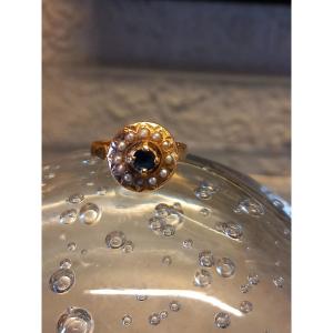 Circular Ring In 18k Gold, In The Center A Sapphire Surrounded By A Row Of Half-pearls.