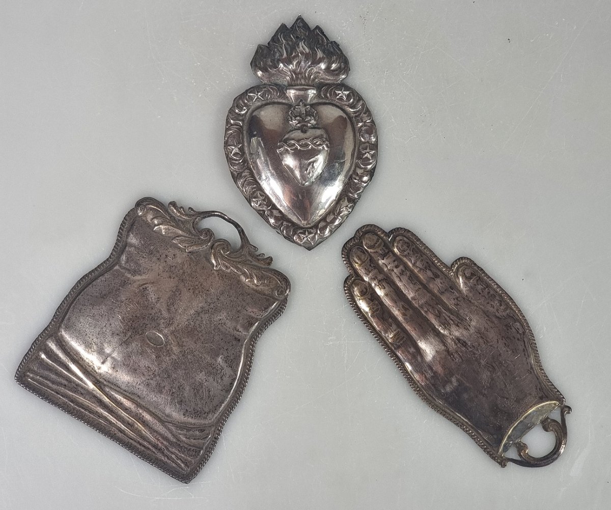 Trois ex-voto anciens en métal argenté – Main, ventre et Sacré-Cœur