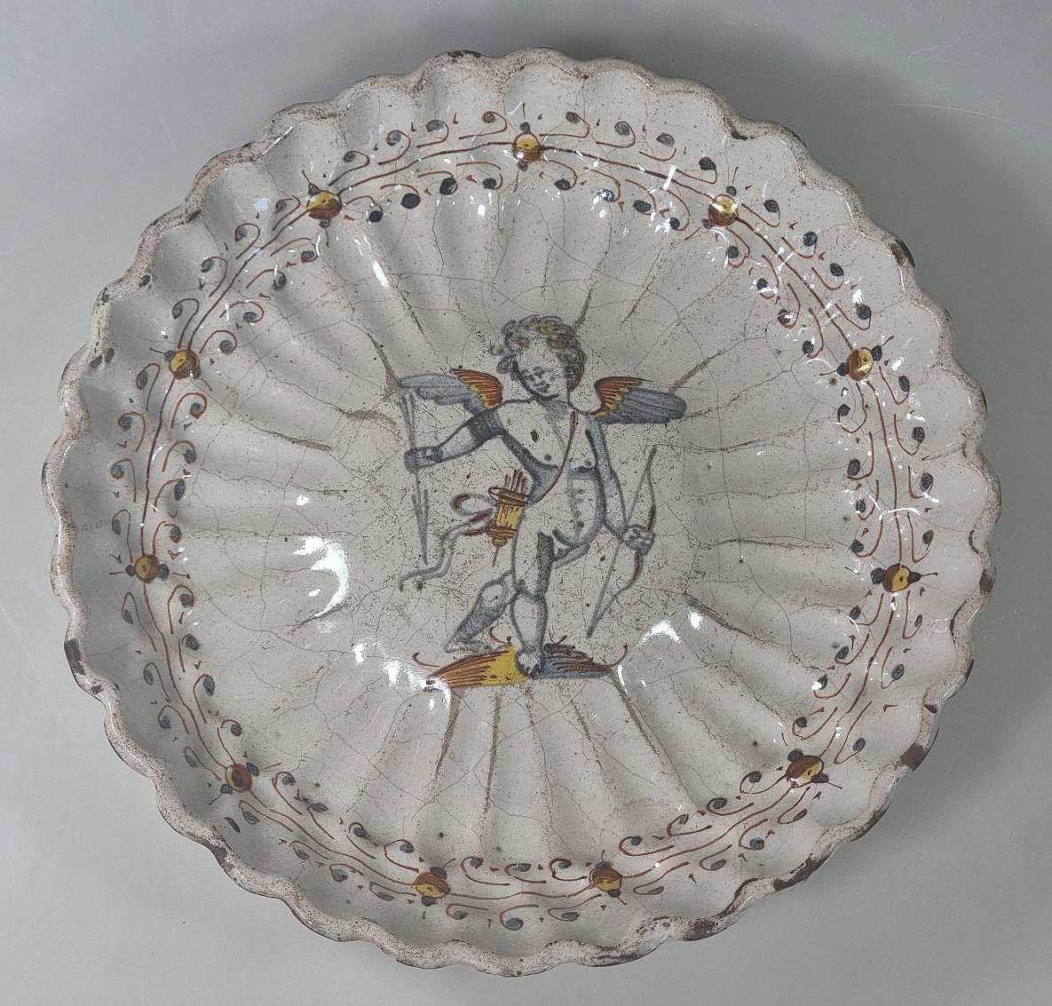 Coupe ancienne en majolique italienne à décor de Cupidon – XVIIe siècle