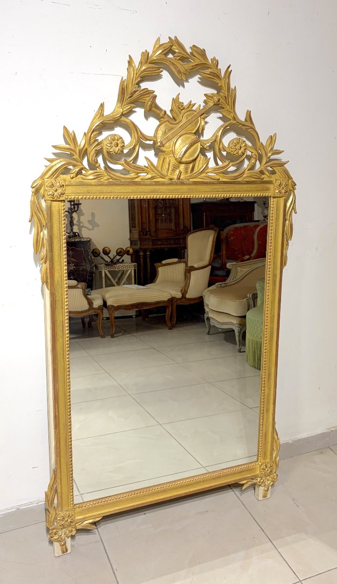 Grand miroir en bois sculpté et doré de style LXVI