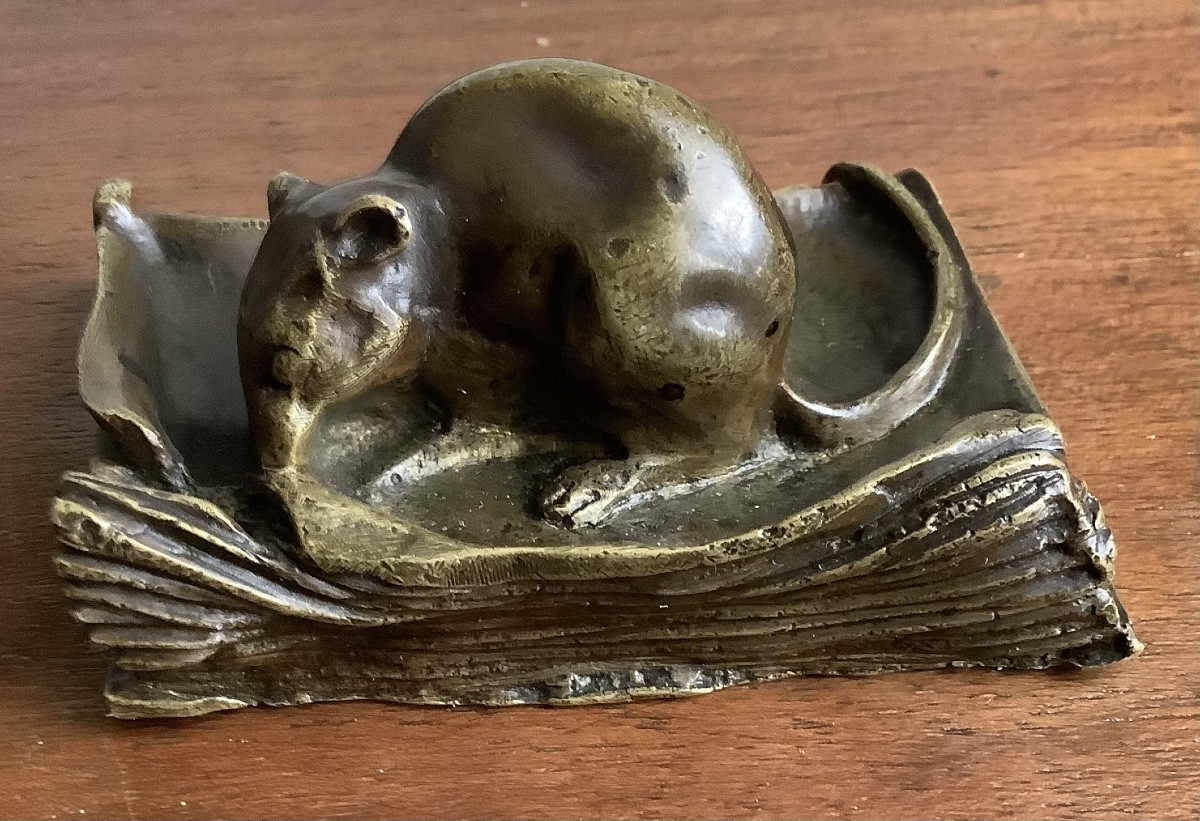 Souris grignotant un livre en bronze