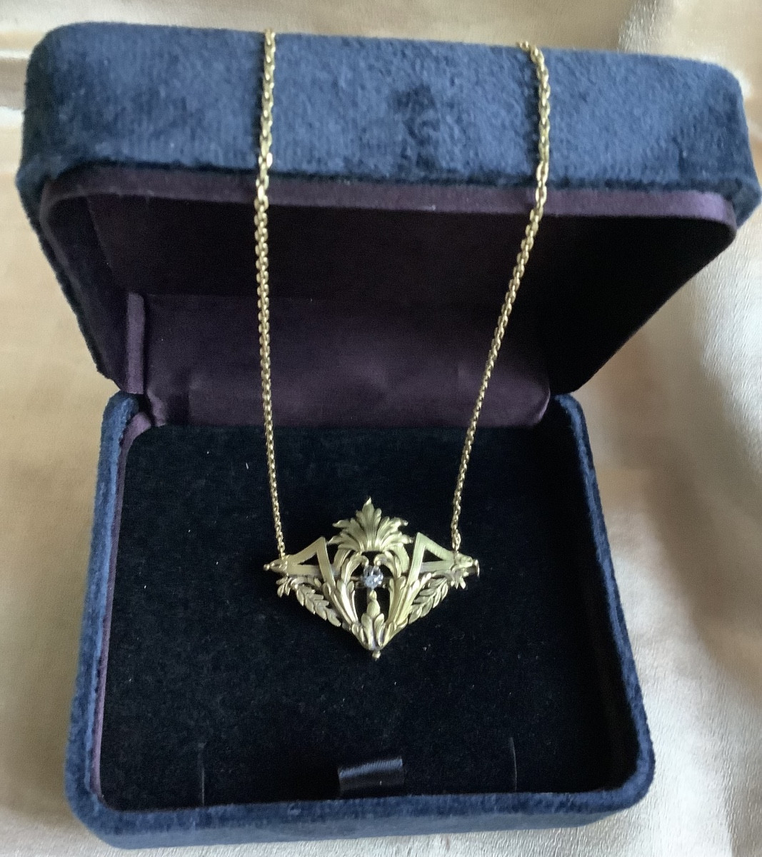 Broche - Pendentif en or ciselé 750 miliémes à decor de guirlande feuillagée, rehaussé diamant