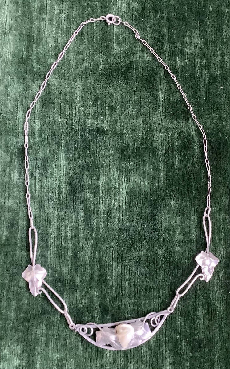 A Silver Necklace Adorned With Leaves In The Center Of A Mother-of-pearl Bead-photo-2