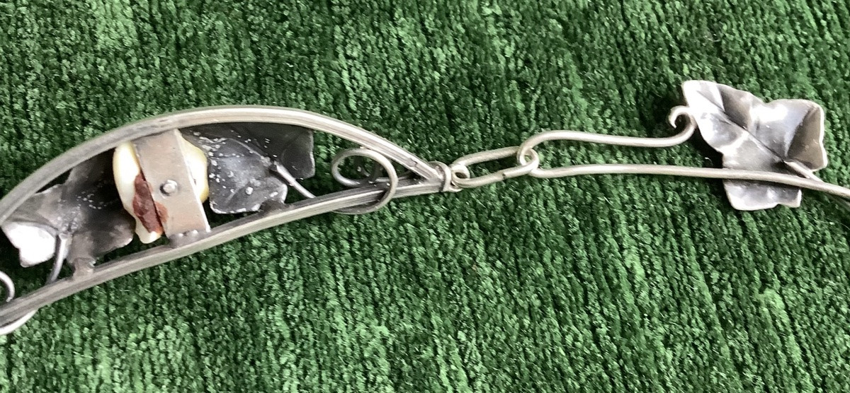 A Silver Necklace Adorned With Leaves In The Center Of A Mother-of-pearl Bead-photo-1