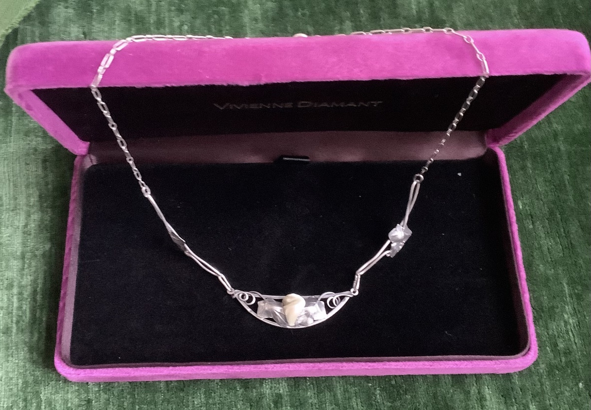 A Silver Necklace Adorned With Leaves In The Center Of A Mother-of-pearl Bead