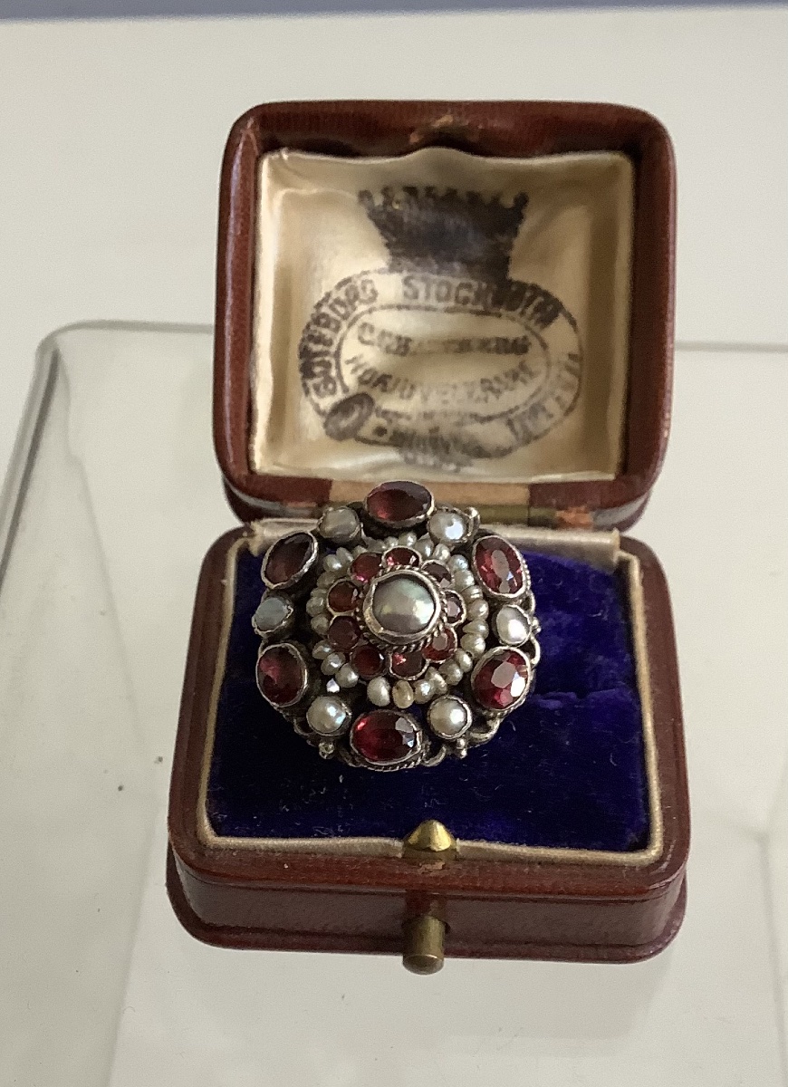 Ring Adorned With A Freshwater Pearl Seed Set In A Garnet Setting