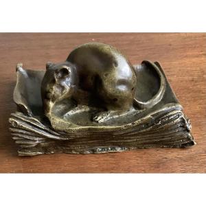 Souris grignotant un livre en bronze
