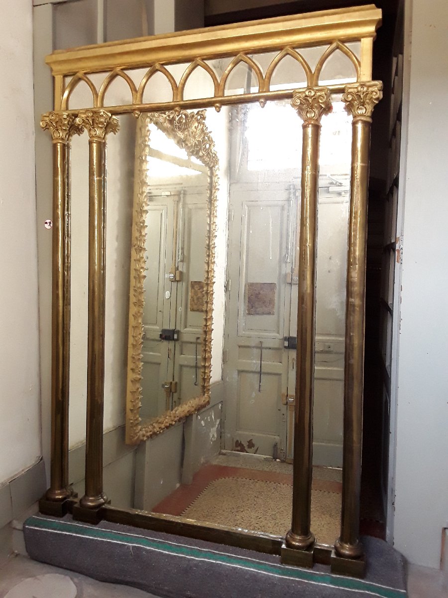 Important miroir en bois doré et colonnes métalliques .