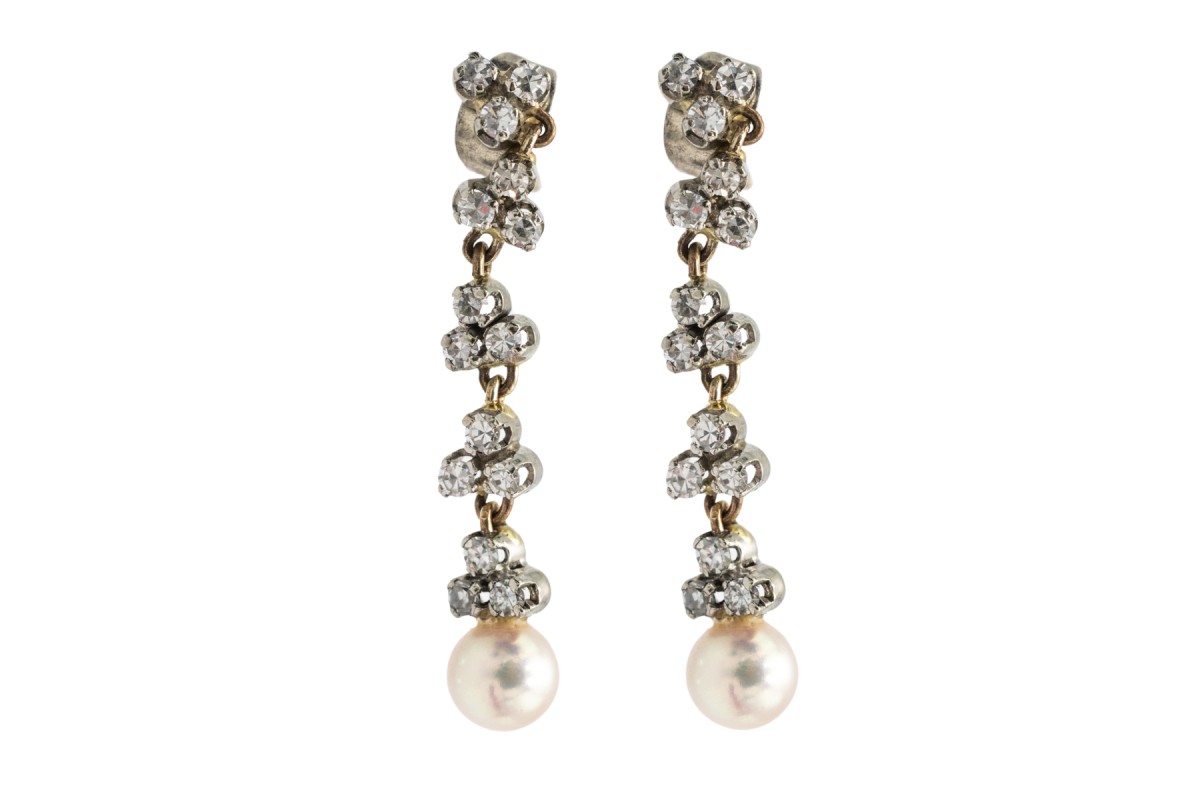 Une paire de boucles d'oreilles unique avec perles et diamants.