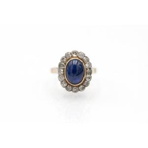 Bague ancienne ornée d’un saphir taille cabochon et d’un entourage de diamants taille ancienne.