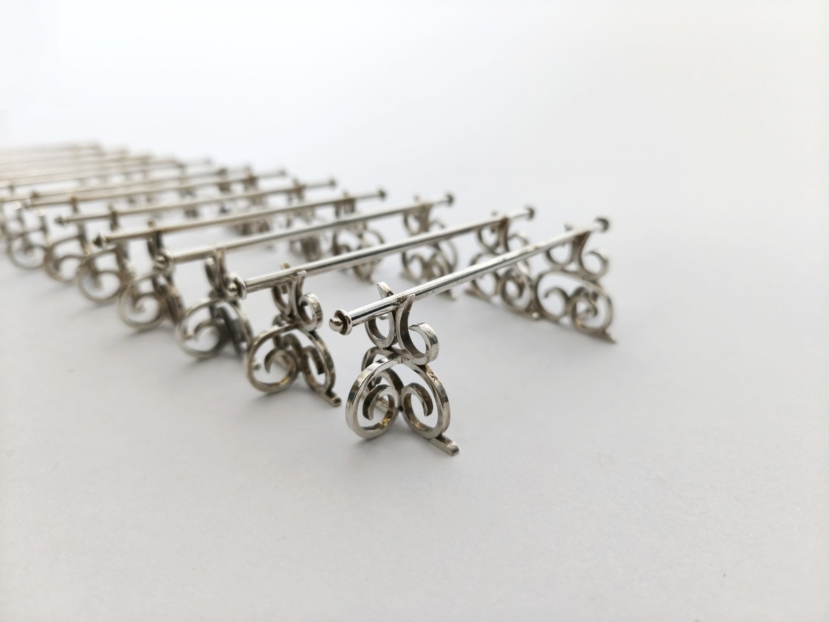 Neo Renaissance : douze porte-couteaux en argent massif à décor d’enroulement.