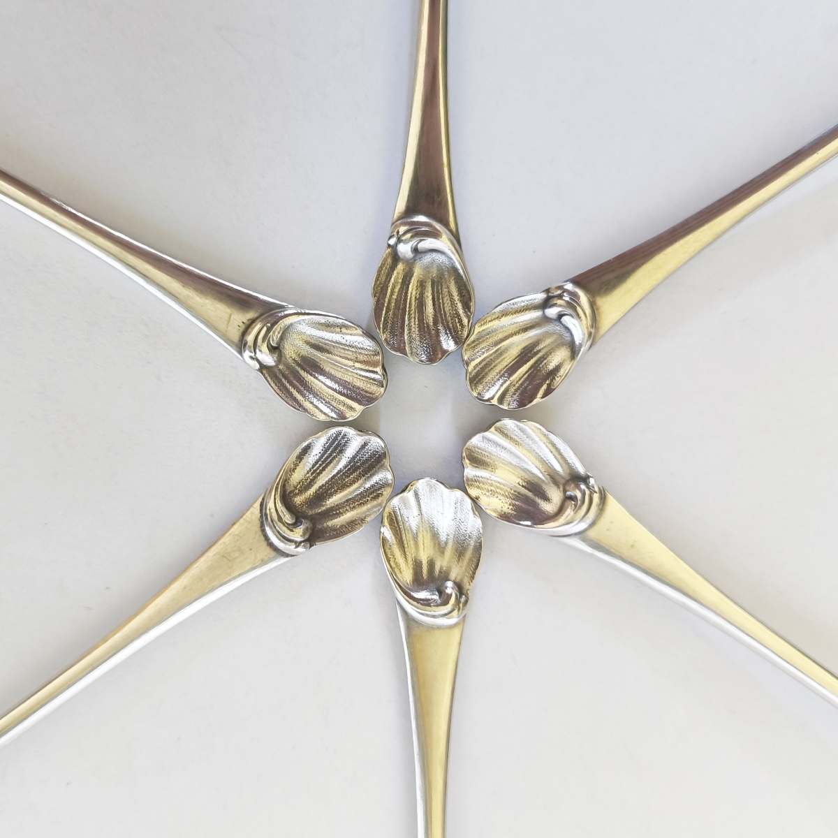 Christofle : six cuillères en métal argenté et doré, décor rocaille de coquilles. 