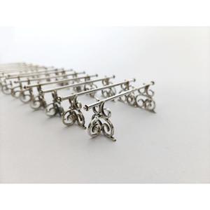 Neo Renaissance : douze porte-couteaux en argent massif à décor d’enroulement. 