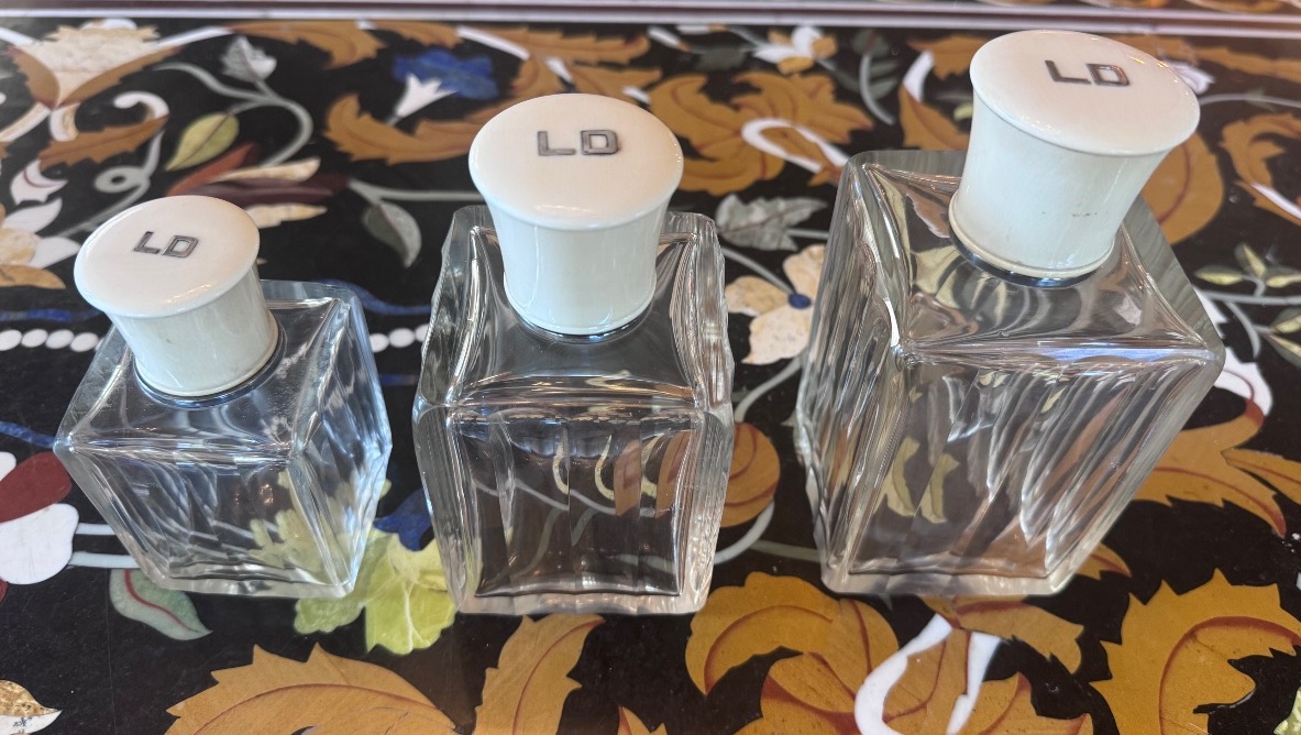 A Set Of Three Perfume Bottles In Crystal, Silver, And Ivory.