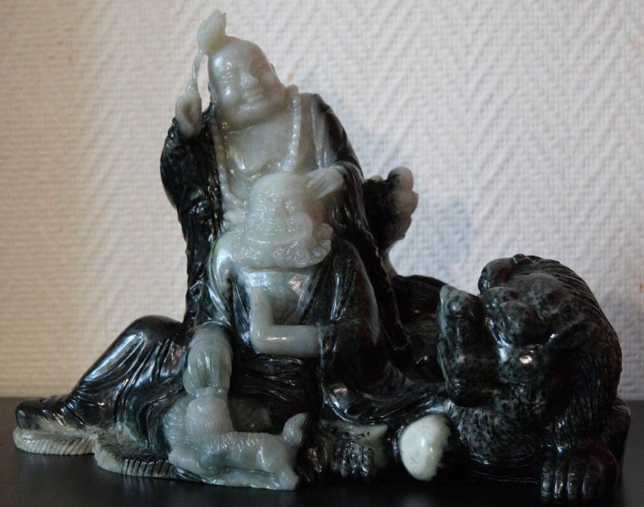 Large Sculpted Group In Two-toned Serpentine Depicting Budai And An Arhat With A Celestial Lion