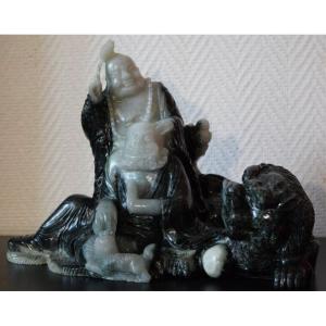 Large Sculpted Group In Two-toned Serpentine Depicting Budai And An Arhat With A Celestial Lion