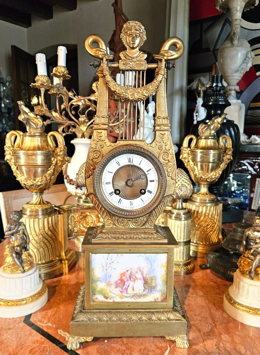 Pendule « à la lyre » d'époque Restauration en bronze doré et plaques de porcelaine peinte, ver