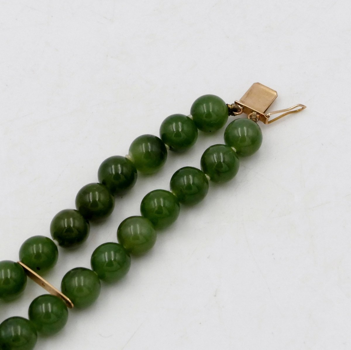 Bracelet or massif et deux rangs de perles de jade vert, milieu XXe siècle.-photo-1