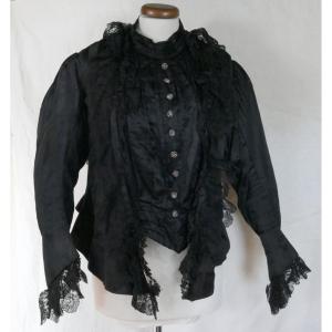 Haut de vêtement féminin avec corset en soie noire et dentelle, fin XIXe siècle.