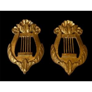 PAIRE D’ORNEMENTS EN BOIS DORÉ SCULPTÉ  À DÉCOR DE LYRE STYLE LOUIS XVI  MILIEU  XIXE SIÈCLE
