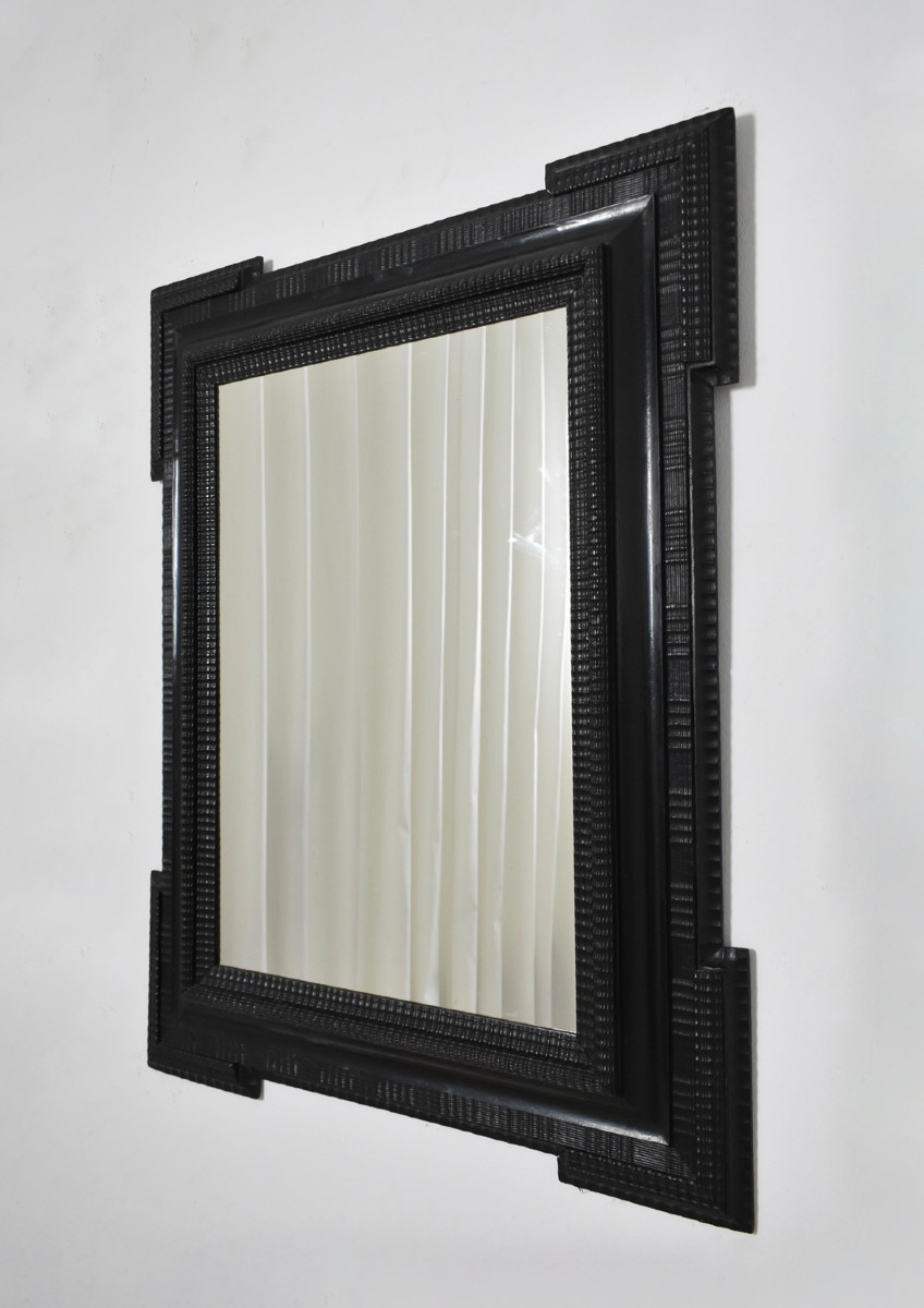 Miroir en bois ébénisé sculpté, XIXe siècle.