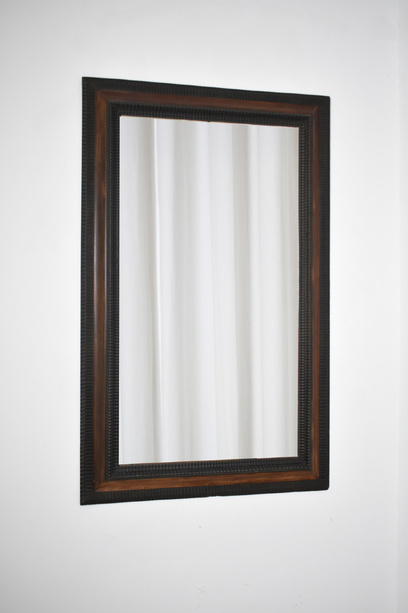 Miroir en bois ébénisé sculpté et écaille de tortue en trompe-l'œil, XIXe siècle.