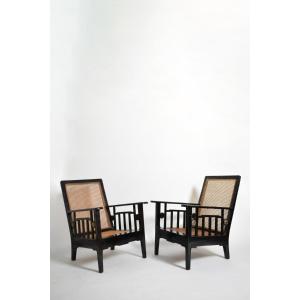 Paire de fauteuils coloniaux en bois ébénisé et cannage, années 1920.