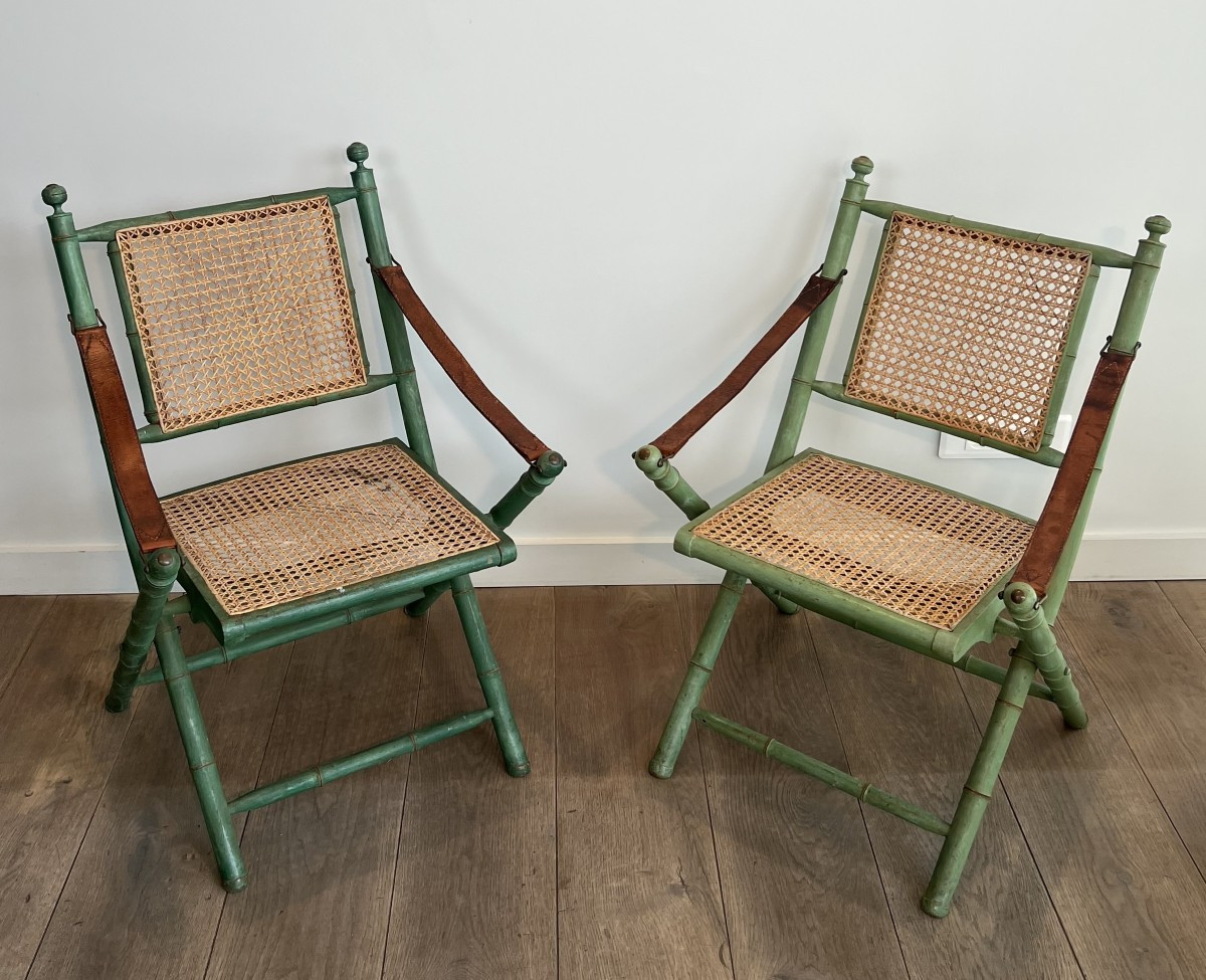 Pair Of Folding Safari Chairs In Patinated Faux Bamboo, Caned Backs And Seats And Leather Arms