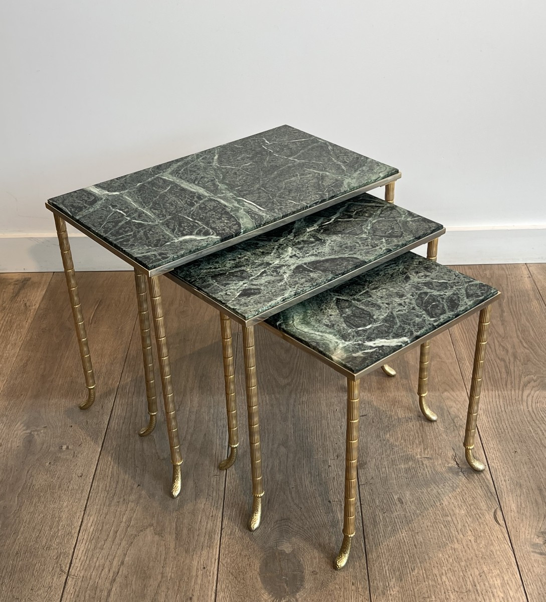 Suite de 3 tables gigognes en métal nickelé et doré à plateaux de marbre vert des Alpes. 