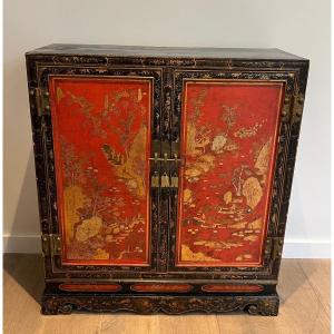 Two Doors Cabinet In Lacquered Wood Presenting Chinese Decorations In Black, Red And Gold Tones