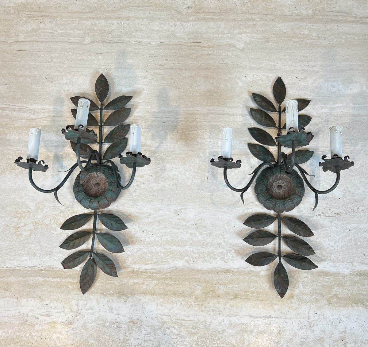 Paire d'appliques décoratives en métal patiné représentant des tournesols et feuillages. 