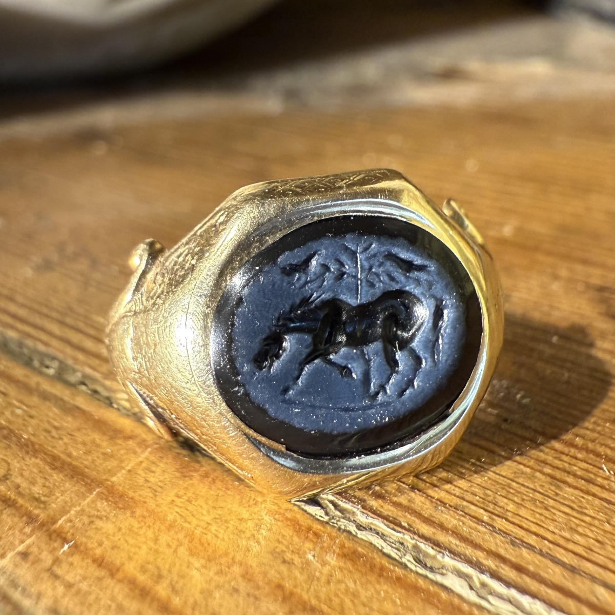 Bague en or du XIXe siècle ornée d'une intaille romaine représentant un cheval devant un arbre.-photo-1