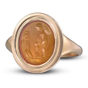 Bague en or avec intaille romaine en cornaline représentant Éros devant un autel.
