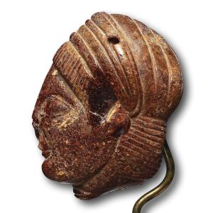 Pendentif tête en ambre étrusque. Étrurie, vers le Ve siècle av. J.-C.