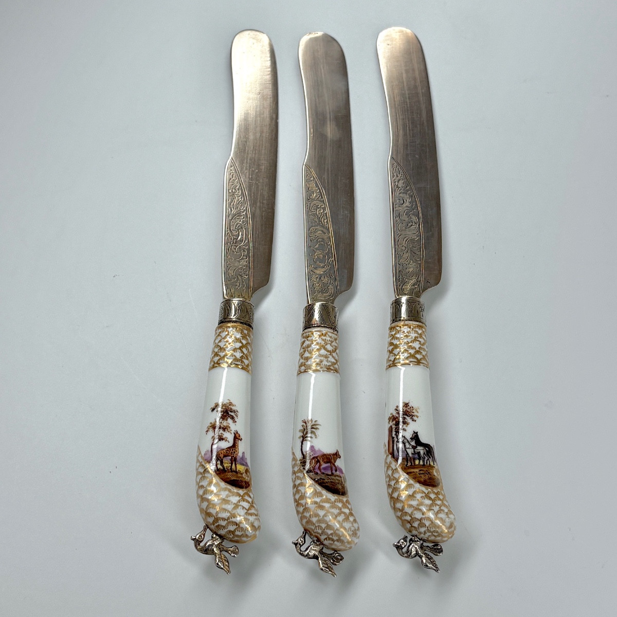 Set Of Three Meissen Porcelain Knives, One Of Which Depicts A Giraffe  Early Nineteenth Century