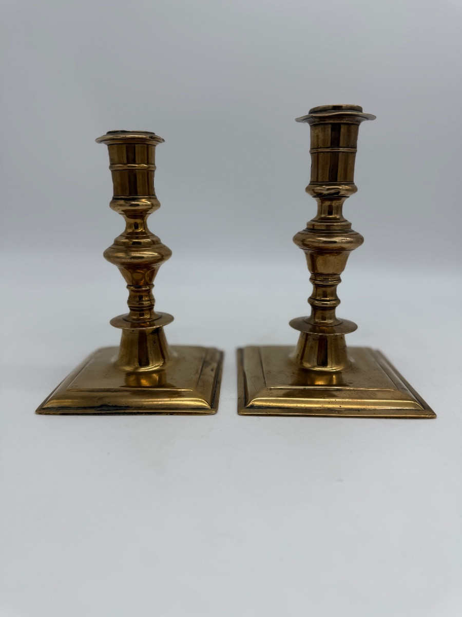 Deux bougeoirs en bronze à bases carrées. 