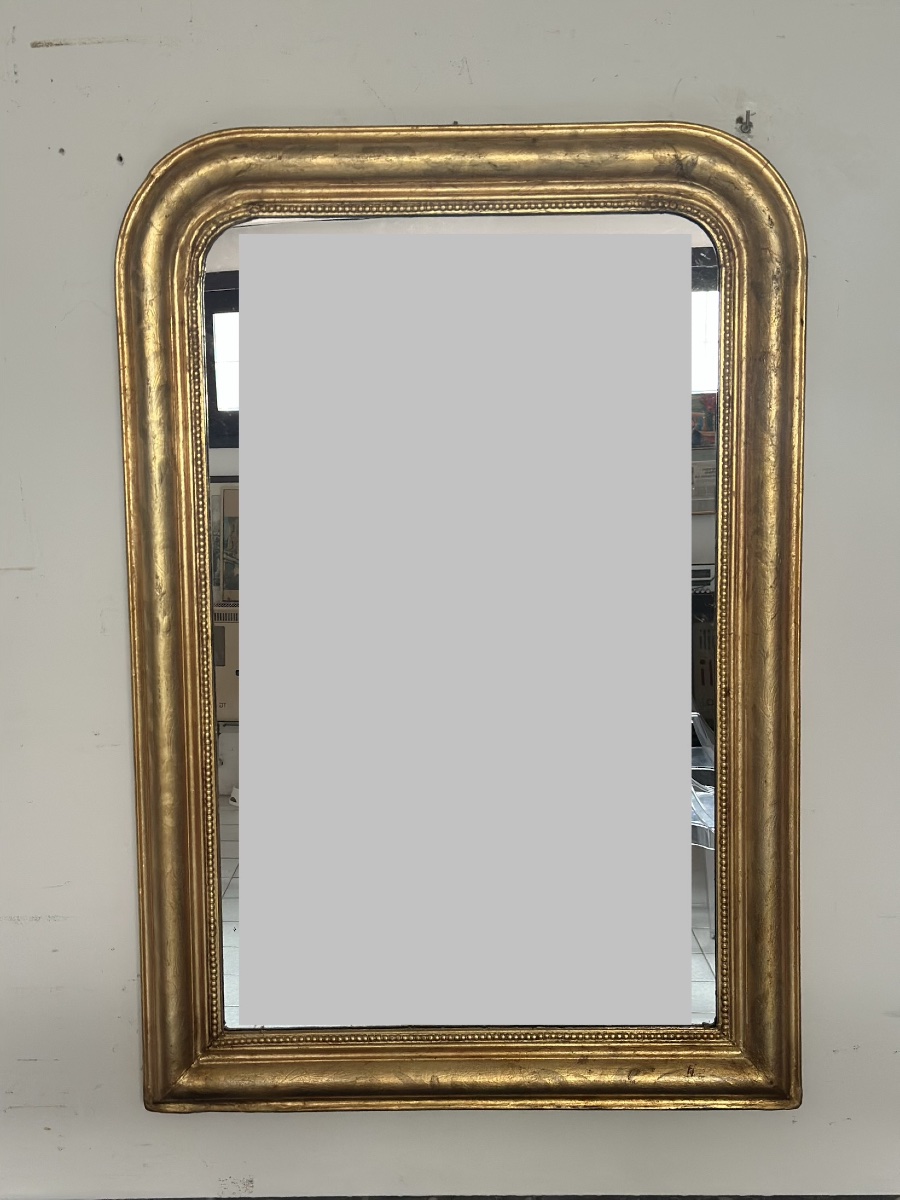 Miroir de la seconde moitié du XIXe siècle en bois doré. Forme rectangulaire à angles arrondis.