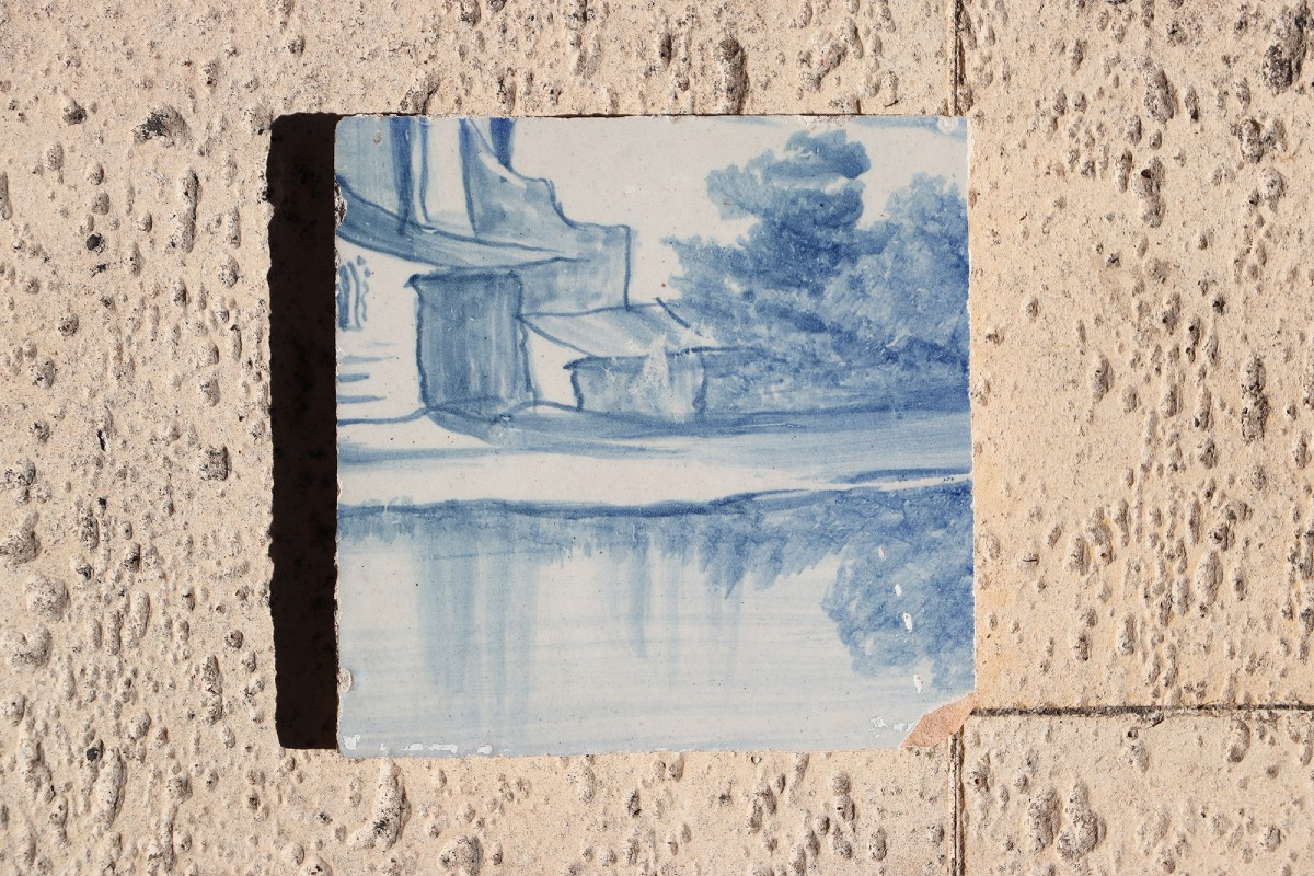 Carreau portugais bleu et blanc du XVIIIe siècle représentant des maisons médiévales au bord 