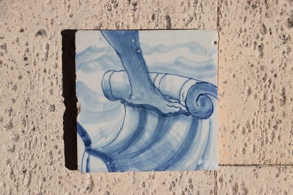 Carreau portugais bleu et blanc du XVIIIe siècle représentant un pied sur un ruban rocaille