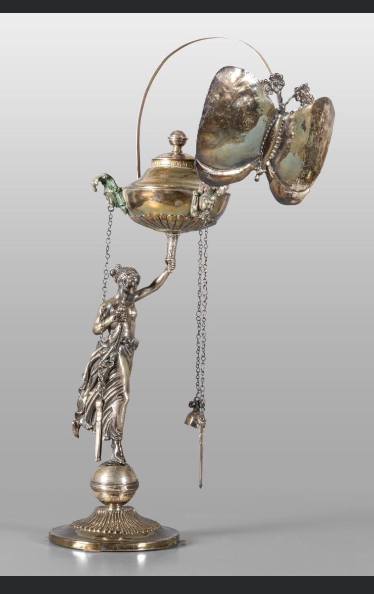 Description  Lampe en argent repoussé représentant une figure néoclassique avec un abat-jour en