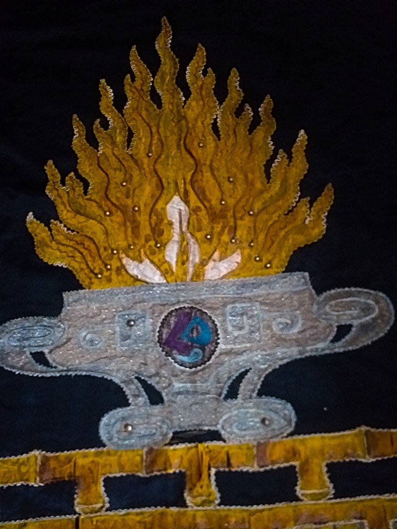 Broderie représentant une coupe contenant une flamme